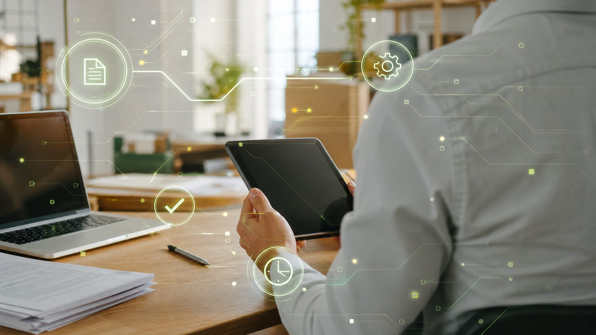 Die KI-Agentur Thüringen führt KI in Betrieben ein, datenschutzkonform und vor Ort. Ein Mitarbeiter hält am Schreibtisch ein Tablet, darüber liegt eine grafische Ebene aus Leiterbahnen und Symbolen für Dokument, Ablauf, Prüfung und Zeit. (KI-generierte Illustration)